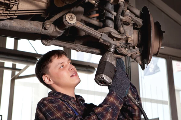 Mécanicien de voiture inspectant roue de voiture et détail de suspension de levage — Photo