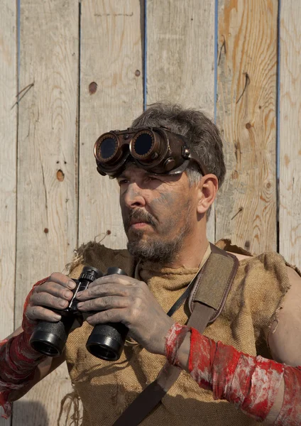 Homem Steampunk usando óculos olha através de um binóculos — Fotografia de Stock