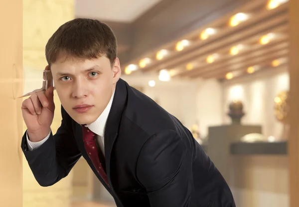 Zakenman spionage door te luisteren via de muur met glas — Stockfoto