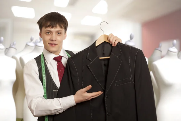 Taylor holds a mans suit — Stock Photo, Image