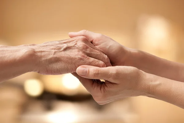 Vrouwelijke handen aanraken van oude mannenhand — Stockfoto