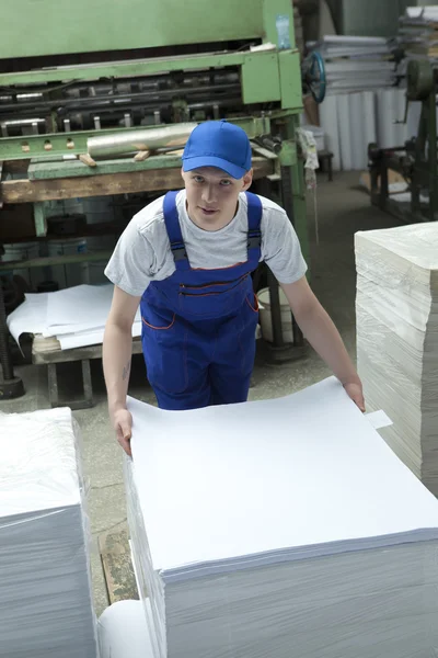 Papel offset de stock. Hombre trabajando en fábrica de impresión — Foto de Stock