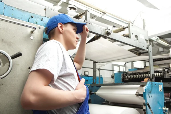 Joven trabajando en fábrica de periódicos — Foto de Stock