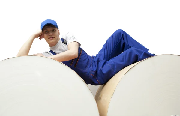 Worker lies on roll of paper in newspaper factory — Stock Photo, Image