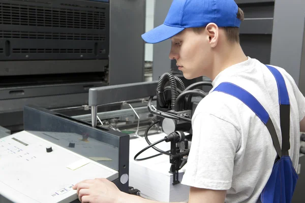 Jonge man aan het werk in print fabriek — Stockfoto