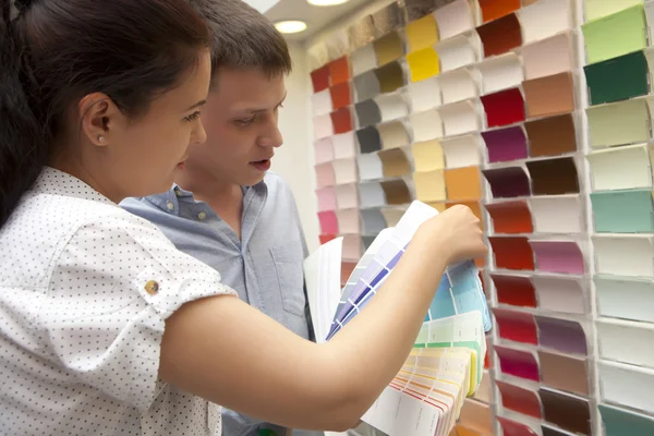 Casal selecione a cor da pintura na loja de ferragens — Fotografia de Stock
