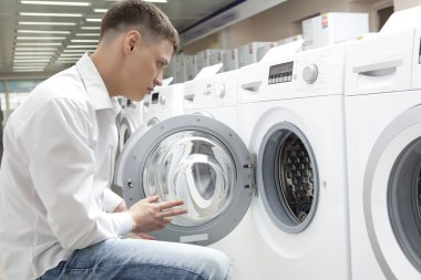 Genç adam yeni çamaşır makinesi satın alma