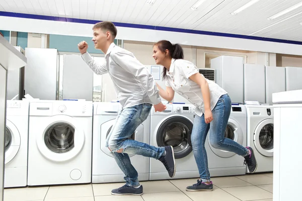 Happy family couple buying new washing machine