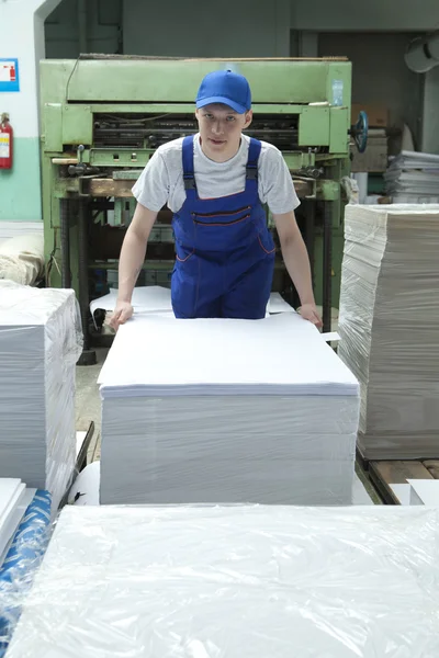 Joven con gorra trabajando en fábrica de impresión — Foto de Stock