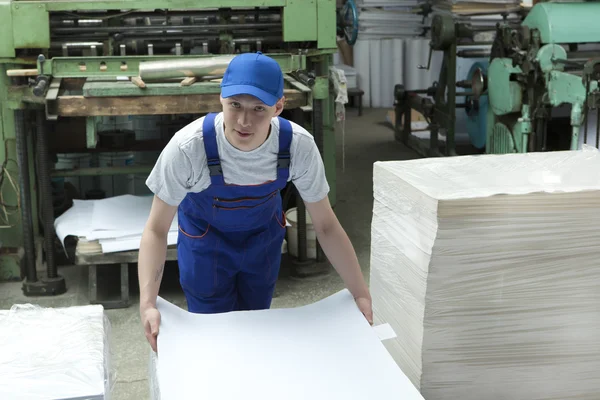 Joven con gorra trabajando en fábrica de impresión —  Fotos de Stock