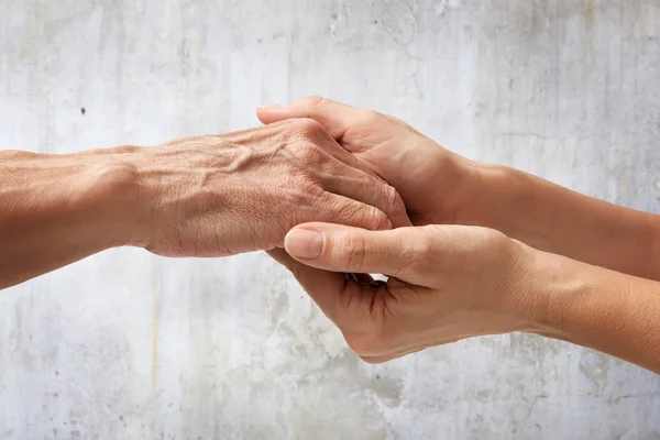 Hands of an elderly man holding the hand of a woman — Stock Photo, Image