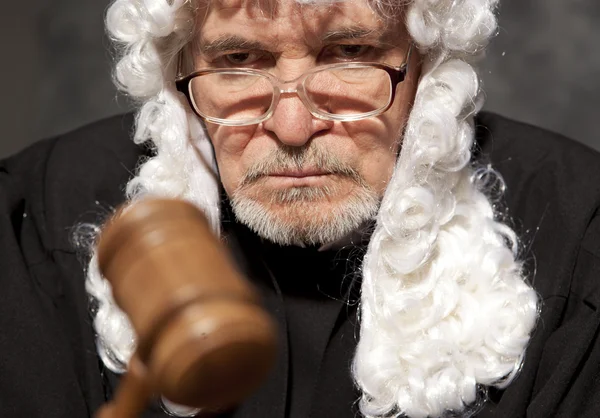 Senior judge in a courtroom striking the gavel — Stock Photo, Image