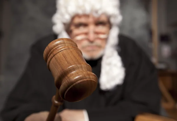 Старший судья в зале суда стучит молотком — стоковое фото