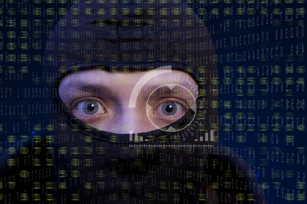 Hacker s kukla přes obrazovku s binárního kódu — Stock fotografie