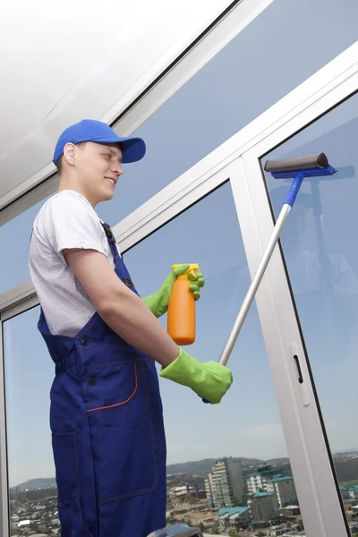 Ung man tvättar fönster — Stockfoto