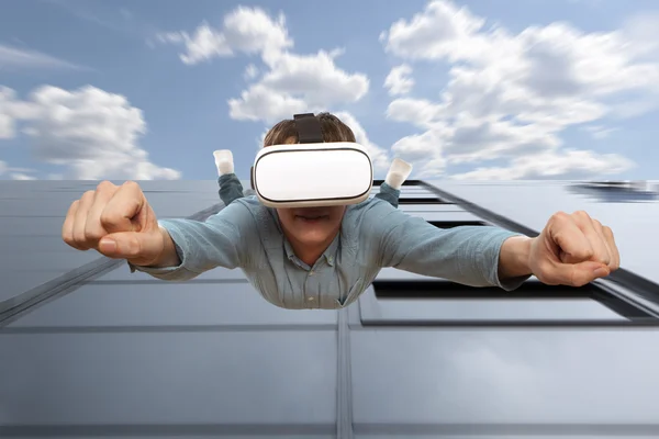 Man wearing virtual reality glasses flying from a skyscraper — Stock Photo, Image