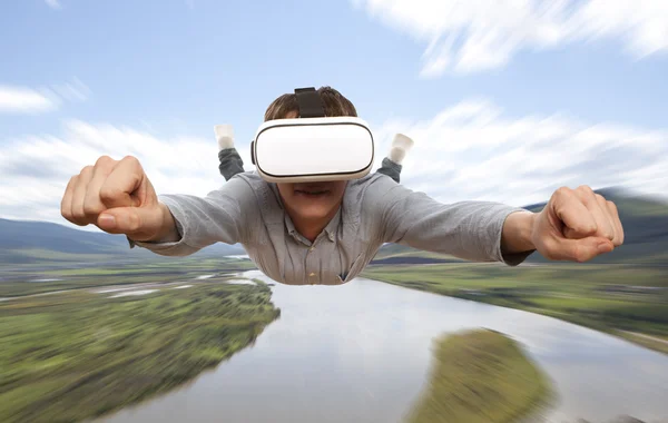 Man wearing virtual reality glasses flies over nature — Stock Photo, Image