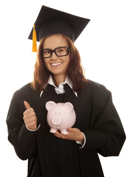 Graduation holding pink piggy bank — Stock Photo, Image