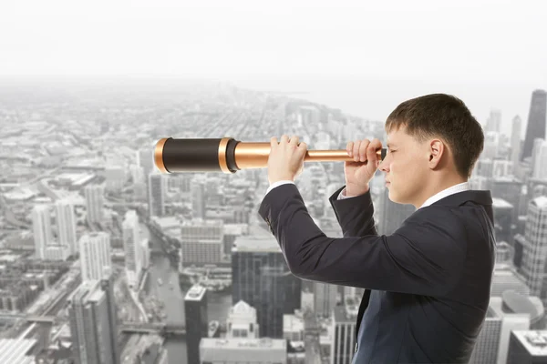 Hombre de negocios mira a través de un telescopio —  Fotos de Stock