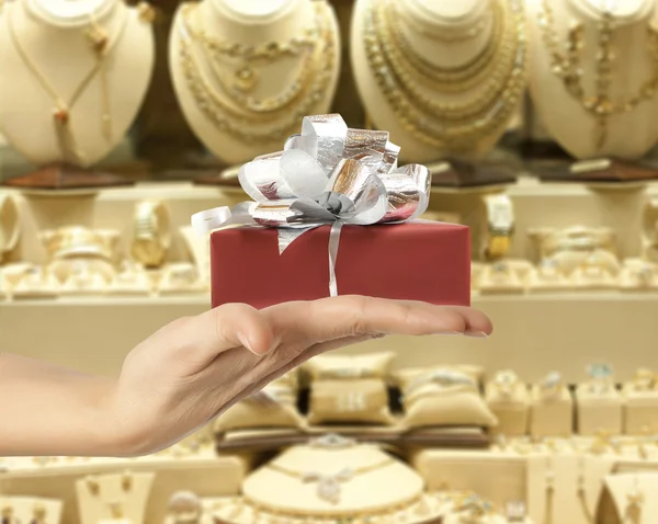 Mão feminina segurando um presente — Fotografia de Stock