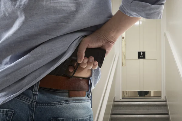 Strážce s pistolí chrání klienta — Stock fotografie
