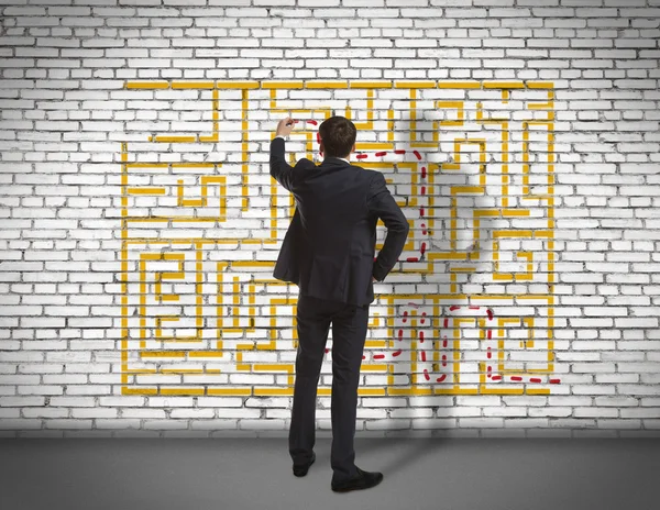 Empresario dibujando laberinto en la pared — Foto de Stock