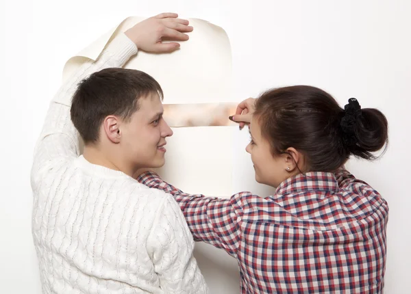 Casal colocando novo papel de parede — Fotografia de Stock