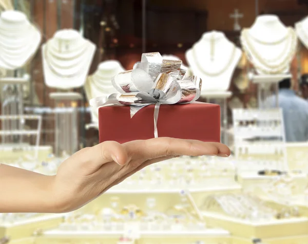 Vrouwelijke hand met een geschenk — Stockfoto