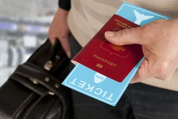 Passport and ticket in hand in airport — Stock Photo, Image