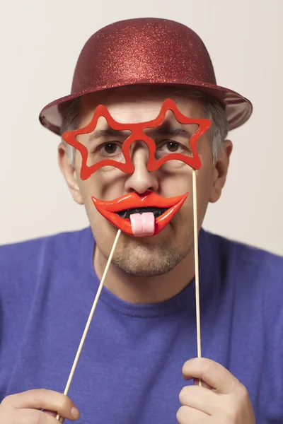 コメディアン。マスクと赤い帽子で陽気な男 — ストック写真