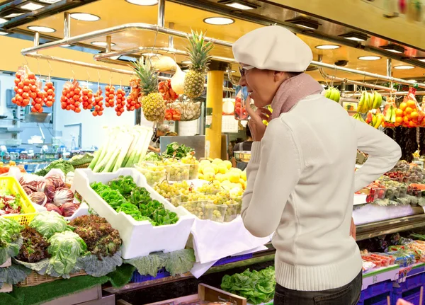 Жінка купує свіжі фрукти та овочі на ринку — стокове фото