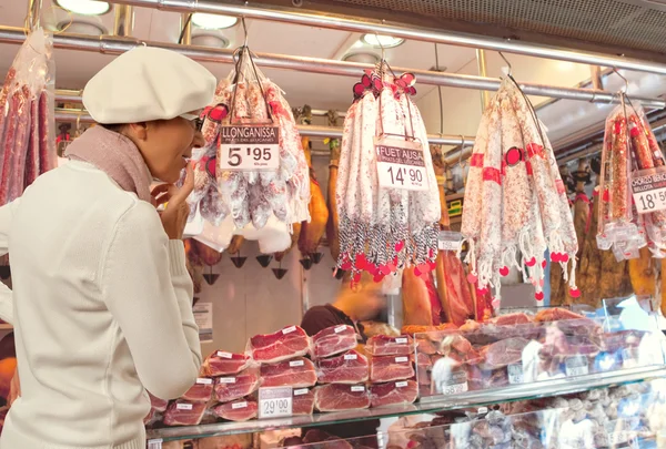 Woman buys smoked sausage in market — Stock Photo, Image