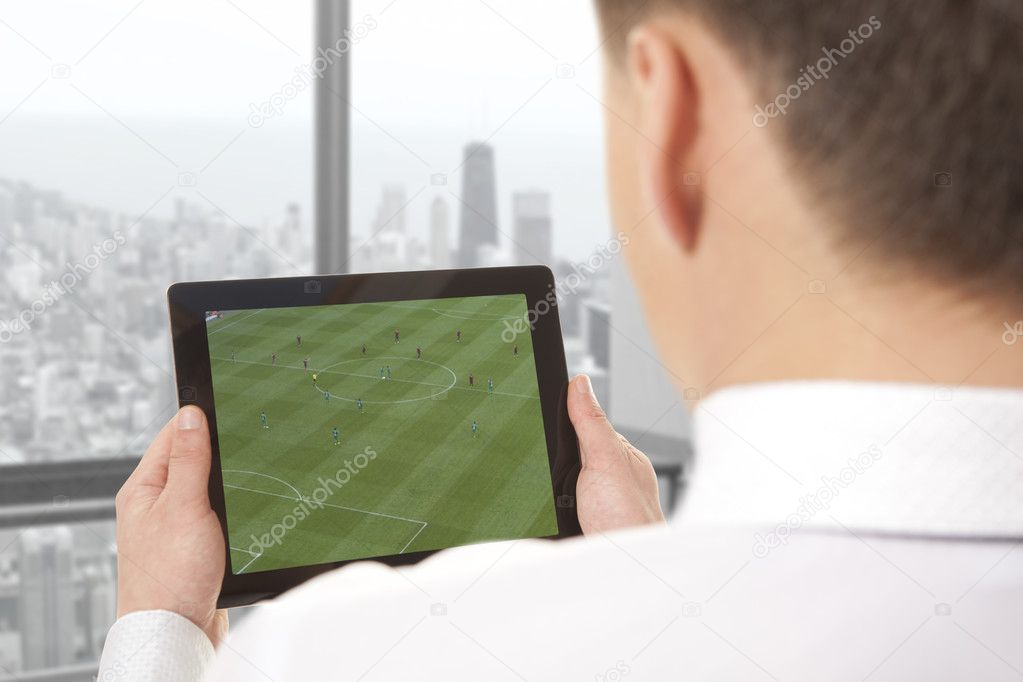 Man with tablet with soccer game