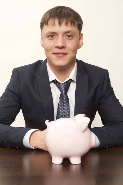 Бизнесмен с розовой копилкой — стоковое фото