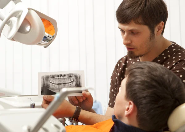 Dentist giving medical consulting to men — Stock Photo, Image