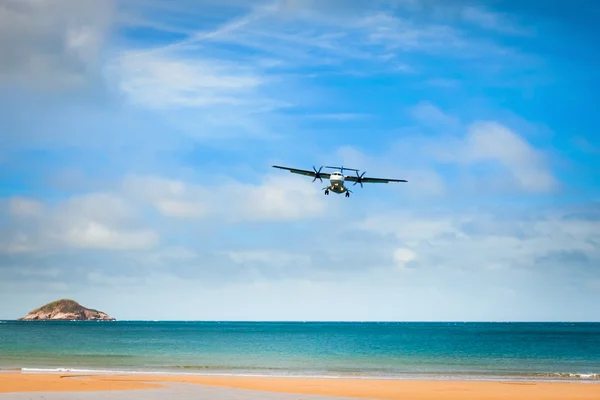 Airplane landing over the tropical lagoon — Stock Photo, Image