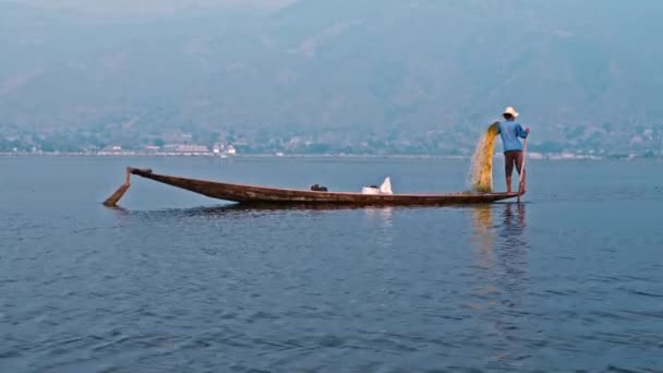 Intha fisherman netting a fish on wooden boat — Stock Video