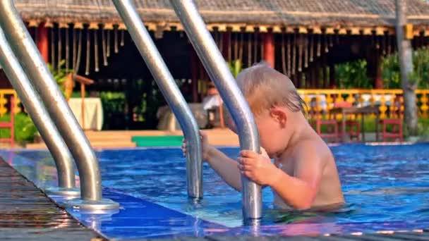 Bambino ragazzo arrampicata fuori dalla piscina — Video Stock