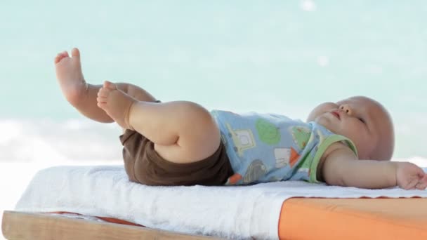 Baby boy plays with his feet — Stock Video