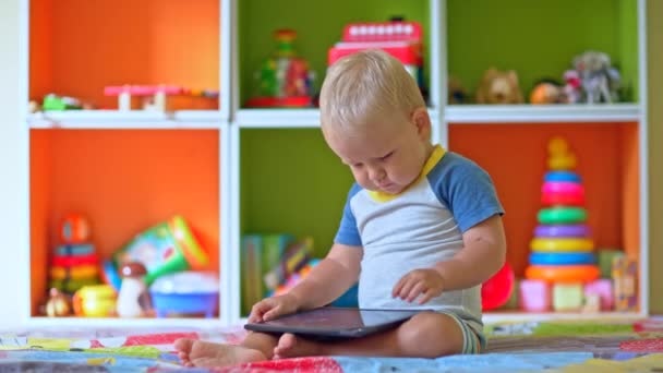 Niño pequeño juega con la tableta — Vídeo de stock