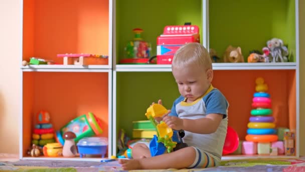 Niño pequeño juega con juguetes — Vídeos de Stock