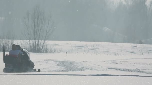 Sneeuwscooter versnellen in de zon — Stockvideo