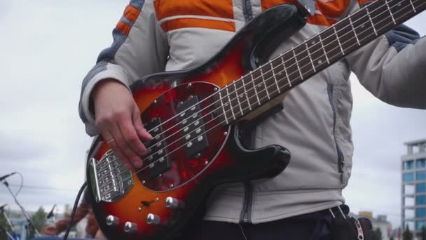 Басист готовится к концерту под открытым небом — стоковое видео