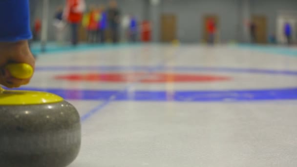 Spelaren rullar en curling stone — Stockvideo