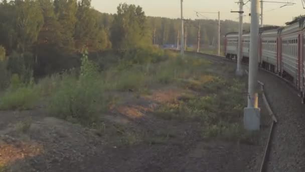 Передміський поїзд на заході сонця — стокове відео