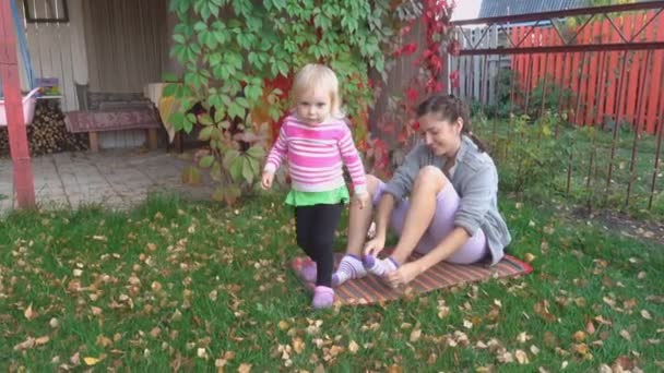 Joven madre y su niña se divierten en otoño — Vídeo de stock