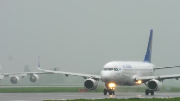 Air Astana Airbus 320 taxning efter landning i regnet. — Stockvideo