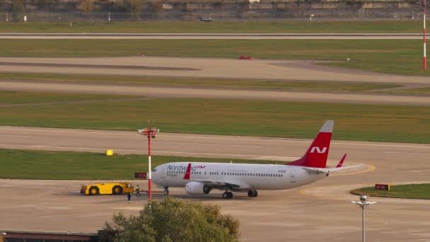 A Boeing 737 típusú légi járművet indulás előtt vontatják.. — Stock videók