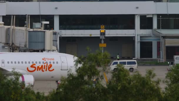 Thai Airlines Smile tira de un remolcador de la terminal — Vídeo de stock