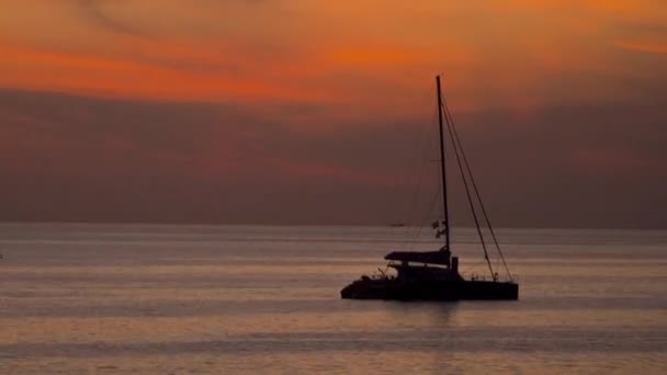 Egy jacht sziluettje naplementekor. — Stock videók